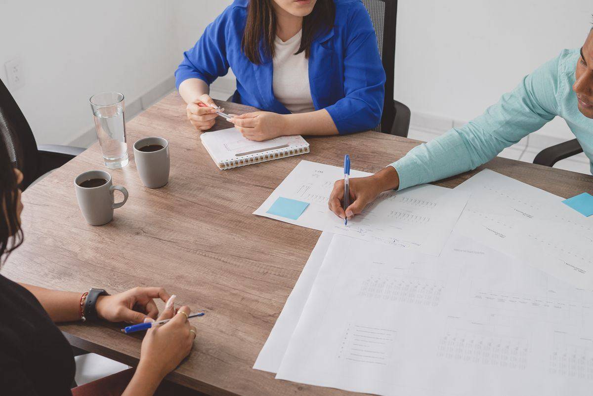 Business meeting discussing plans around a table with documents